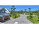 Expansive driveway leads to this stunning home surrounded by lush landscaping and palm trees at 630 De Narvaez Dr, Longboat Key, FL 34228