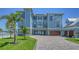 Stunning three-story waterfront home with lush landscaping and spacious driveway offers coastal living at 630 De Narvaez Dr, Longboat Key, FL 34228