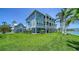 Beautiful three-story home with porches on a well manicured lawn with access to water at 630 De Narvaez Dr, Longboat Key, FL 34228