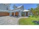 Detached garage with multiple bays features wooden doors and manicured lawn with cobblestone driveway at 630 De Narvaez Dr, Longboat Key, FL 34228
