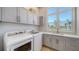 Bright laundry room with modern washer, dryer, and ample cabinet space and lovely water view at 630 De Narvaez Dr, Longboat Key, FL 34228