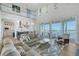 Open-concept living room with a high ceiling, water views, and adjacent kitchen at 630 De Narvaez Dr, Longboat Key, FL 34228