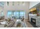 Bright living room with a stone fireplace, large windows, and scenic waterfront views at 630 De Narvaez Dr, Longboat Key, FL 34228