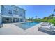 Backyard pool with plenty of lounge chairs behind a gorgeous blue home at 630 De Narvaez Dr, Longboat Key, FL 34228