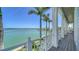 Stunning waterfront view from the deck, with palm trees framing the turquoise water, offering a serene outdoor living space at 630 De Narvaez Dr, Longboat Key, FL 34228