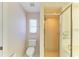 Bright bathroom with a toilet, tiled shower, and small window at 645 Liberty St, Englewood, FL 34223