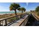 Scenic wooden walkway leading to a pristine beach, enhanced by the beauty of swaying palm trees at 645 Liberty St, Englewood, FL 34223