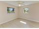 Bright bedroom with light colored walls, two windows, wood-look floors, and ceiling fan at 645 Liberty St, Englewood, FL 34223