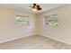 Bedroom with laminate wood flooring, ceiling fan, and natural light from two windows at 645 Liberty St, Englewood, FL 34223