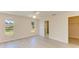 Bright bedroom with light-colored walls, wood-look floors, ceiling fan, and two windows at 645 Liberty St, Englewood, FL 34223
