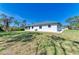 Exterior side view of the house surrounded by a well maintained grassy area at 645 Liberty St, Englewood, FL 34223