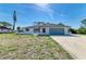 Charming single-story home with a two-car garage, red front door, and a well-lit sky at 645 Liberty St, Englewood, FL 34223
