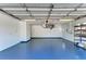 Clean garage featuring a blue painted floor, shelving, and a storage area at 645 Liberty St, Englewood, FL 34223