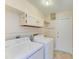 Laundry room featuring a washer, dryer, utility sink and upper cabinet at 645 Liberty St, Englewood, FL 34223