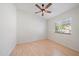 Neutral bedroom with wood-look floors, ceiling fan, and a window view to the exterior at 6552 Meandering Way, Lakewood Ranch, FL 34202