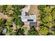 An aerial view of a home with a screened pool, metal roof, and lush landscaping providing backyard privacy at 6990 Richardson Rd, Sarasota, FL 34240