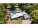 An aerial view showing a home with an in-ground pool, screened lanai, and a metal roof at 6990 Richardson Rd, Sarasota, FL 34240