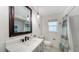 Updated bathroom with a framed mirror, modern vanity, and shower with decorative curtain at 6990 Richardson Rd, Sarasota, FL 34240