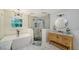 Modern bathroom features a freestanding tub, glass shower, wooden vanity, and stylish chandelier at 6990 Richardson Rd, Sarasota, FL 34240