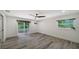 Bright bedroom with a ceiling fan, stylish flooring, and glass door leading to the yard at 6990 Richardson Rd, Sarasota, FL 34240