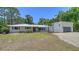 A view of the home's exterior showing the lawn, driveway and meticulously maintained landscaping at 6990 Richardson Rd, Sarasota, FL 34240