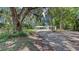 Charming home featuring a shell driveway and mature trees offering privacy and curb appeal at 6990 Richardson Rd, Sarasota, FL 34240