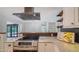Updated kitchen featuring stainless steel appliances, island cooktop, and seamless flow to the sunroom at 6990 Richardson Rd, Sarasota, FL 34240