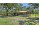 Exterior of a vintage shed with a fenced yard and mature trees in the background at 6990 Richardson Rd, Sarasota, FL 34240