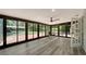 Sunroom with luxury vinyl plank flooring, wall of windows with view of the backyard, and furniture at 6990 Richardson Rd, Sarasota, FL 34240