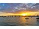Beautiful waterfront view of the sunset, featuring a bridge, sailboat, and calm water reflecting the golden sunlight at 6990 Richardson Rd, Sarasota, FL 34240