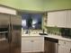 Bright kitchen with stainless steel appliances, white cabinets, and a view to the living room at 7273 Cedar Hollow Cir # 102, Bradenton, FL 34203