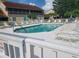 Community pool surrounded by lounge chairs and lush landscaping at 7273 Cedar Hollow Cir # 102, Bradenton, FL 34203