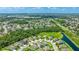 Wide aerial shot of houses nestled among trees, with a pond and the distant skyline visible at 7379 47Th Avenue E Cir, Bradenton, FL 34203