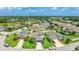 Aerial view of a house with a well-manicured lawn, mature trees, and a circular driveway in a residential area at 7379 47Th Avenue E Cir, Bradenton, FL 34203