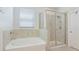 This bathroom features a garden tub with custom tile and a glass-enclosed shower at 7379 47Th Avenue E Cir, Bradenton, FL 34203
