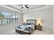 A spacious bedroom features a ceiling fan, large window, and a beautiful bed with matching end tables at 7379 47Th Avenue E Cir, Bradenton, FL 34203