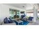 Relaxing covered patio with comfortable seating area, a TV, and sliding glass doors to the interior at 7379 47Th Avenue E Cir, Bradenton, FL 34203