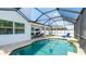 Screened-in pool area features a beautiful pool, patio seating and a blue lounge chair for relaxing by the water at 7379 47Th Avenue E Cir, Bradenton, FL 34203