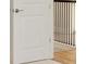 White door with metallic handle leading to hallway with metal stair railing at 7533 Nighthawk Drive, Sarasota, FL 34241