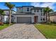 Charming two-story home with a gray exterior, a two-car garage, and beautifully landscaped front yard at 7533 Nighthawk Drive, Sarasota, FL 34241