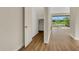 Bright hallway with wood floors leading to an open closet and views of backyard lake at 7533 Nighthawk Drive, Sarasota, FL 34241