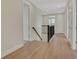 Bright hallway with wood floors, white trim, and sleek dark metal stair railing at 7533 Nighthawk Drive, Sarasota, FL 34241
