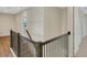 Bright hallway features wood floors, a staircase with dark wood and iron railings, and white walls at 7533 Nighthawk Drive, Sarasota, FL 34241