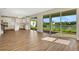 Bright living room with wood floors and sliding glass doors offering a picturesque pond view at 7533 Nighthawk Drive, Sarasota, FL 34241