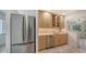 Contemporary kitchen features stainless steel appliances, natural wood cabinetry, and tiled floors at 755 Edgemere Ln, Sarasota, FL 34242