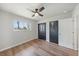Bedroom with window letting in natural light, closet, ceiling fan and wood look floors at 7595 Berwick St, North Port, FL 34287