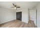 Bright bedroom featuring a ceiling fan, closet, and wood-look floors; a serene retreat at 7595 Berwick St, North Port, FL 34287