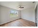Cozy bedroom with wood-look flooring, a large window for natural light, and a ceiling fan at 7595 Berwick St, North Port, FL 34287