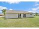 Back exterior of home featuring a large backyard, siding and sliding glass doors at 7595 Berwick St, North Port, FL 34287