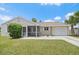 Charming single-story home featuring a screened porch, attached garage, and manicured lawn at 7595 Berwick St, North Port, FL 34287